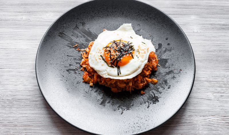 Ein typisches Gericht mit Kimchi ist Kimchi Bokkeumbap, eine Art Reispfanne, die üblicherweise mit einem Spiegelei serviert wird.